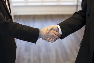 Two business professionals shaking hands in an office setting