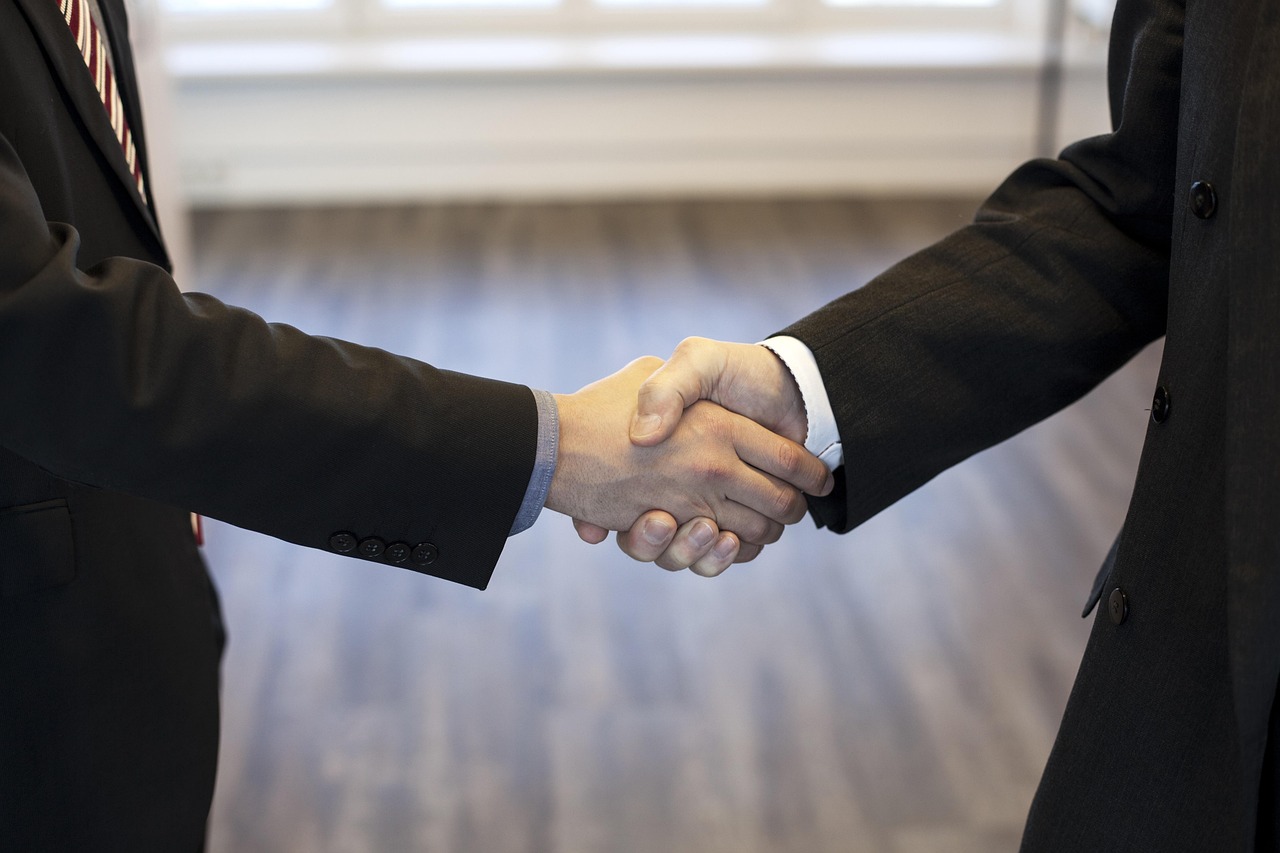 Two business professionals shaking hands in an office setting