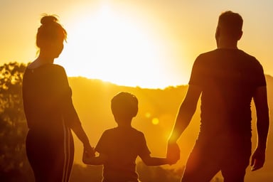 Silhouette of a family holding hands at sunset