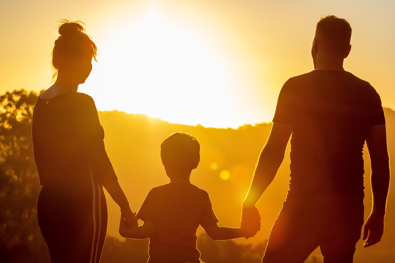 Silhouette of a family holding hands at sunset