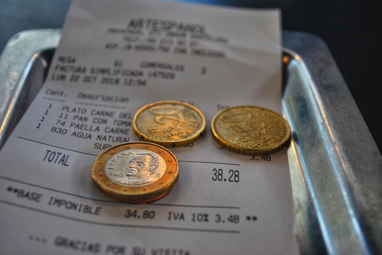 Receipt with coins on a tray, showcasing currency and pricing.